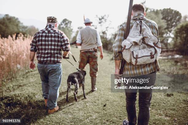 group of hunters walking with dog in swamp - hobby bird of prey stock pictures, royalty-free photos & images