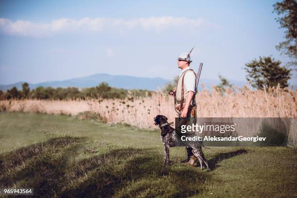 hunter searching for birds with his faithful dog - feather hat stock pictures, royalty-free photos & images