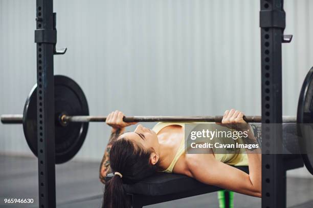 woman doing bench press in gym - barbell stock pictures, royalty-free photos & images