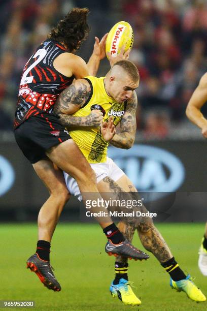 Dustin Martin of the Tigers hammers into Mark Baguley of the Bombers during the round 11 AFL match between the Essendon Bombers and the Richmond...