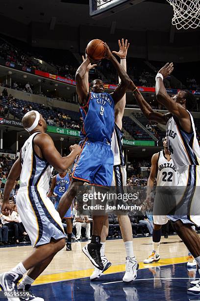 Serge Ibaka of the Oklahoma City Thunder goes up for a shot against Jamaal Tinsley and Hasheem Thabeet of the Memphis Grizzlies during the game at...