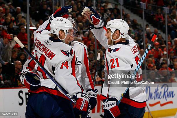 Tomas Fleischmann of the Washington Capitals celebrates his goal against the Ottawa Senators with teammates Alexander Semin and Brooks Laich in a...