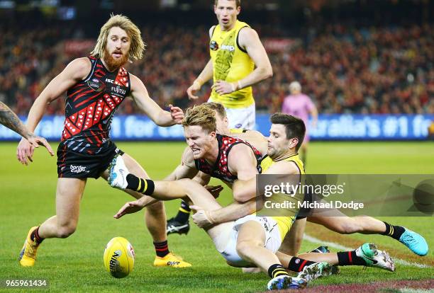 Trent Cotchin of the Tigers tackles James Stewart of the Bombers during the round 11 AFL match between the Essendon Bombers and the Richmond Tigers...