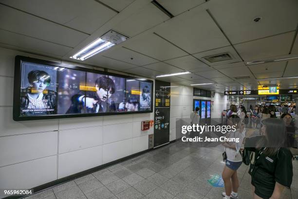 Fans take pictures of video images of BTS at Hongdae Subway Station put up by approximately 80 fans to celebrate BTS' 5th anniversary, on June 2,...