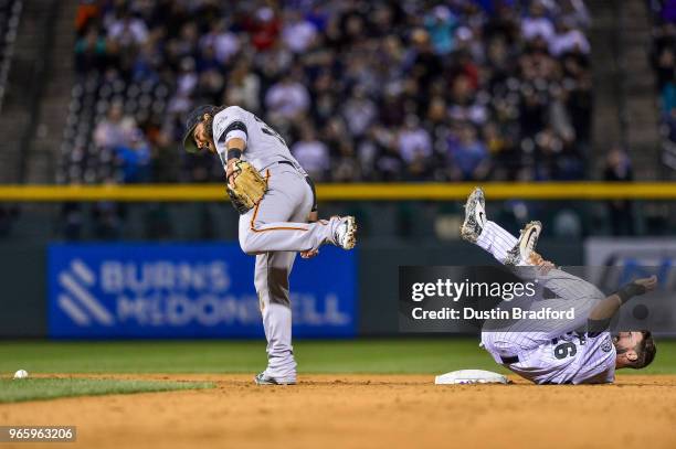 David Dahl of the Colorado Rockies slides safely into second base and dislodges the ball from the glove of Brandon Crawford of the San Francisco...