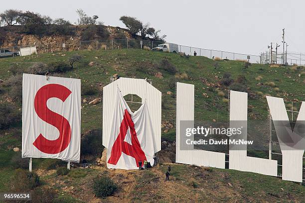 Activists begin covering up the iconic 450-foot-long Hollywood sign during an effort to prevent the building of houses there on February 11, 2010 in...