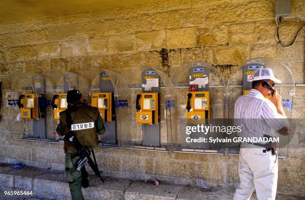 Settler on the phone bearing weapon in Cisjordan. Colon armé de Cisjordanie au téléphone.