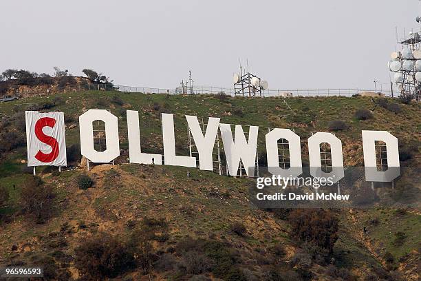 Activists begin covering up the iconic 450-foot-long Hollywood sign during an effort to prevent the building of houses there on February 11, 2010 in...