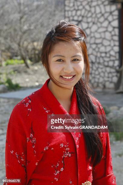 Bhutan, District of Paro, the road to Taktschang, traditional house, young lady // Bhoutan , district de Paro, la ville, la route vers Taktshang,...