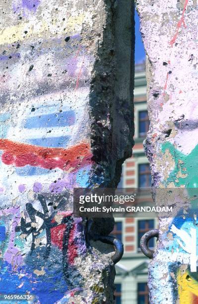 GERMANY.BERLIN.OBERBAUMBR?CKE BRIDGE QUARTER.REMNANTS OF THE BERLIN WALL WITH GRAFITTIS.HOLE BETWEEN TWO PIECES.