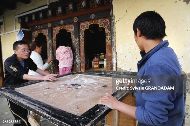Bhutan , District of Paro, the City,young men playing traditional game // Bhoutan , district de Paro, la ville, hommes jeunes jouant a un jeu...