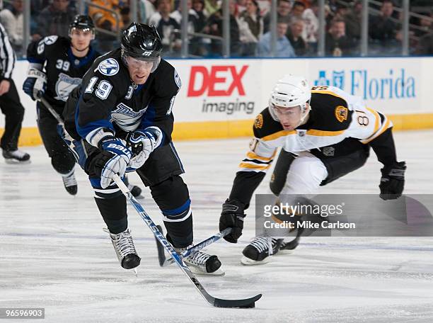 Stephane Veilleux of the Tampa Bay Lightning tries to get control of the puck against Miroslav Satan of the Boston Bruins at the St. Pete Times Forum...