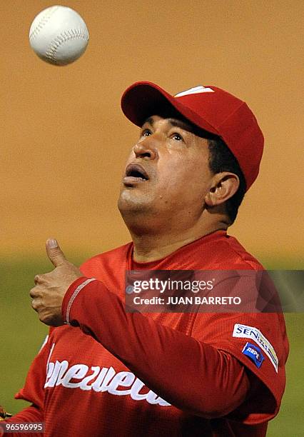 Venezuelan President Hugo Chavez tosses a ball in the air before a softball match with professional Venezuelan players in Caracas on February 11,...