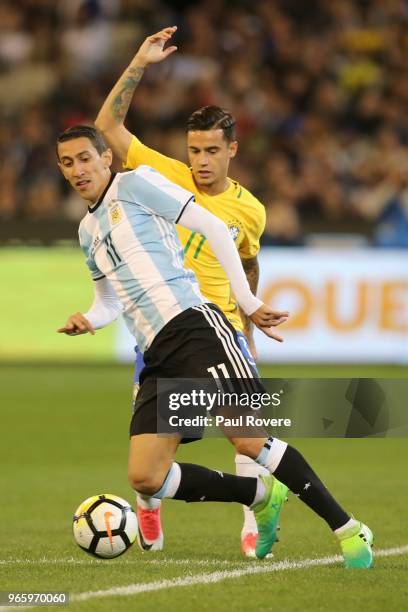 Angel Di Maria of Argentina leads Philippe Coutinho of Brazil to the ball during the Brazil Global Tour match between Brazil and Argentina at...