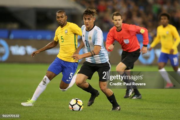 Paulo Dybala of Argentina leads Fernandinho of Brazil to the ball during the Brazil Global Tour match between Brazil and Argentina at Melbourne...