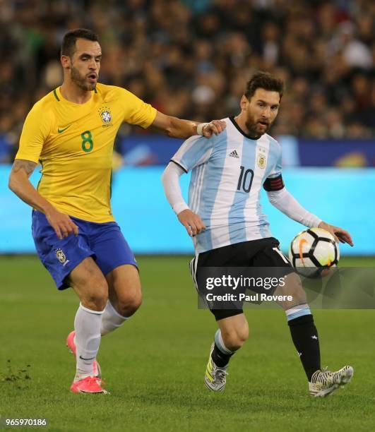 Lionel Messi of Argentina leads Renato Augusto of Brazil to the ball during the Brazil Global Tour match between Brazil and Argentina at Melbourne...