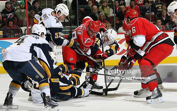 Patrick Dwyer and Brandon Sutter of the Carolina Hurricanes battle for the puck against Craig Rivet, Steve Montador, and Michael Grier of the Buffalo...