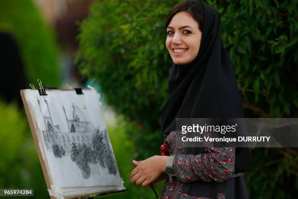 Jeune fille avec le nez refait realisant un dessin de la Place de L'Imam, Ispahan, 18 mai 2016, Iran. La chirurgie esthetique du nez, qui coute entre...