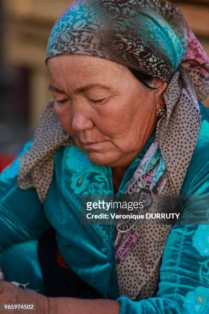 Portrait de vieille femme portant le foulard traditionnel, vendeuse au bazar Chorsu à Tachkent, Ouzbekistan.
