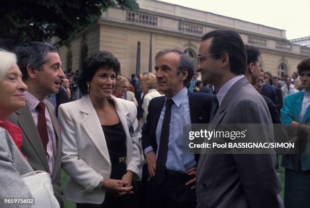 Les journalistes lvan Levaï et Anne Sinclair avec l'écrivain Elie Wiesel et l'économiste Jacques Attali lors de la traditionnelle garden-party du 14...