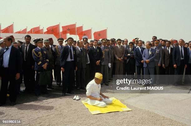 Le roi Hassan II du Maroc en train de prier lors de sa visite officielle à la ville d'El-Ayoun et de sa région le 16 mars 1985, Sahara occidental.