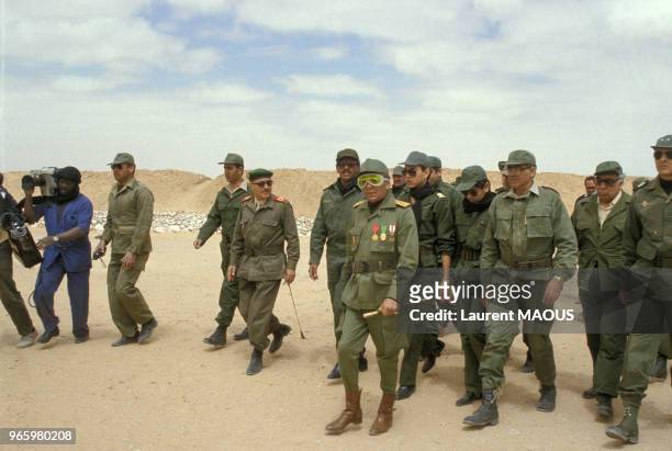 Le roi Hassan II du Maroc en uniforme militaire, suivi de ses fils les princes Sidi Mohammed et Moulay Rachid et de ses officiers, lors de sa visite...