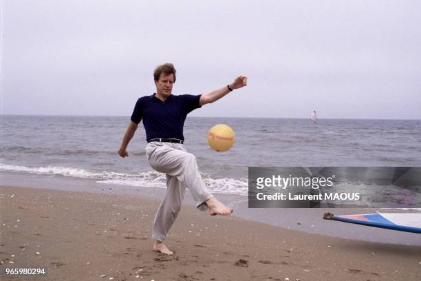 Acteur André Dussollier joue au ballon sur la plage pendant le Festival du film romantique le 22 juin 1986 à Cabourg, France.