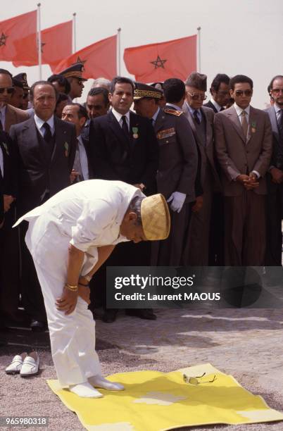 Le roi Hassan II du Maroc en train de prier lors de sa visite officielle à la ville d'El-Ayoun et de sa région le 16 mars 1985, Sahara occidental.