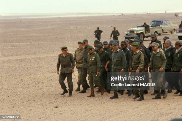 Le roi Hassan II du Maroc en uniforme militaire, suivi de ses fils les princes Sidi Mohammed et Moulay Rachid et de ses officiers, lors de sa visite...