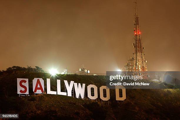 The light of a police helicopter illuminates the work of activists after they stopped work for the night on covering up the iconic 450-foot-long...