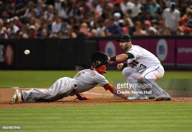Daniel Descalso of the Arizona Diamondbacks gets ready to catch a throw from pitcher Zack Godley as Billy Hamilton of the Cincinnati Reds dives back...