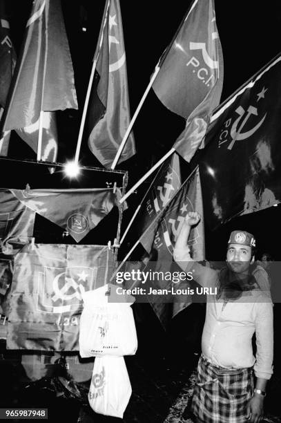 Drapeaux du Parti communiste et militant levant le poing lors des élections municipales le 22 juin 1976 à Rome, Italie.