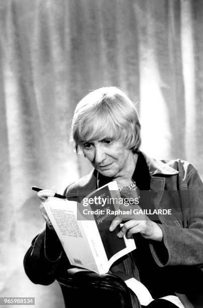 écrivaine Françoise Sagan à la FNAC Etoile à Paris, France, le 16 octobre 1998, son livre 'Derrière l'épaule..' et stylo en mains.