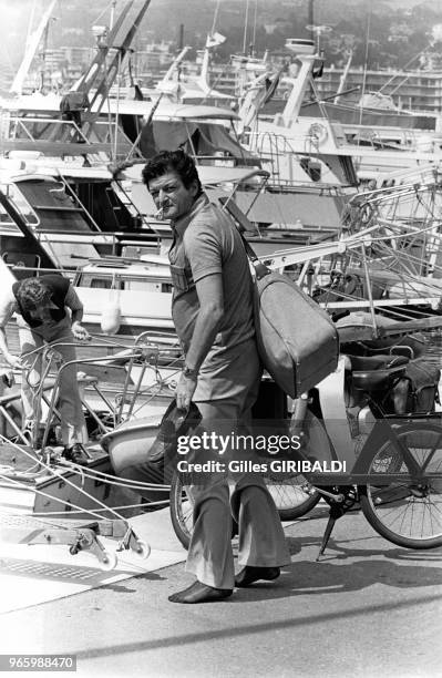 L'écrivain et journaliste Paul Bonnecarrère, chaussures à la main et sac sur le dos prêt à monter sur le bateau à quai à Saint-Tropez, France, en...