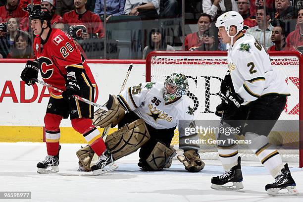 Curtis Glencross of the Calgary Flames skates against Marty Turco and Nicklas Grossman of the Dallas Stars on February 11, 2010 at Pengrowth...