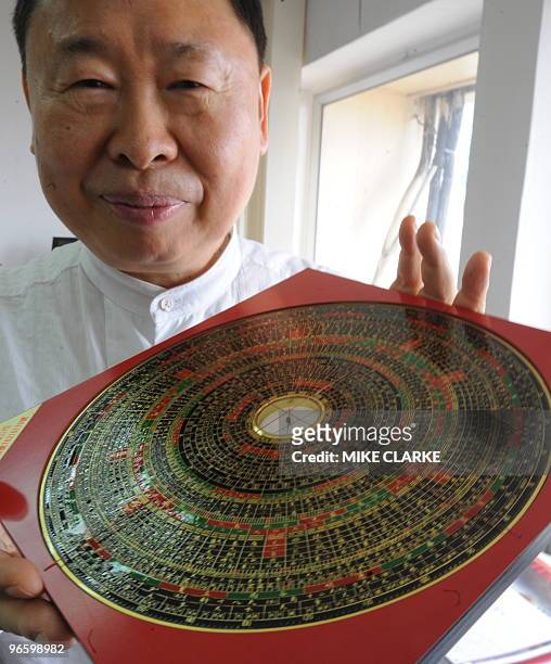 To go with AFP story by Polly Hui: LUNAR-HONGKONG-LIFESTYLE-OFFBEAT Feng shui expert Raymond Lo poses with a chinese compass, or Loupan, at his...