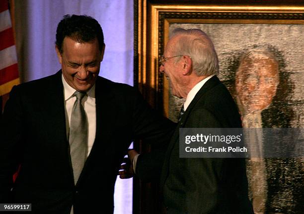 Actor Tom Hanks and Captain James A. Lovell Jr. Share a laugh while leaving the stage after unveiling a painting that was presented to Lovell when he...