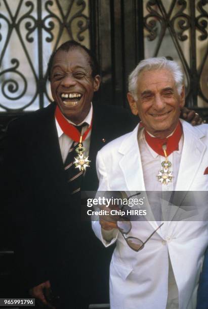 écrivain James Baldwin et le chef d'orchestre Leonard Bernstein décorés de la croix de chevalier de la Légion d'honneur le 19 juin 1986 à Paris,...