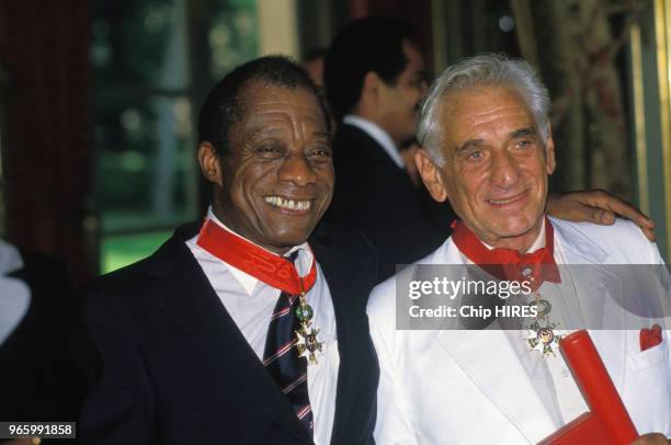 écrivain James Baldwin et le chef d'orchestre Leonard Bernstein décorés de la croix de chevalier de la Légion d'honneur le 19 juin 1986 à Paris,...