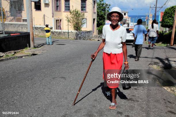 Jamaican old woman walking on the street on December 27, 2011 in Port Antonio, Jamaica.