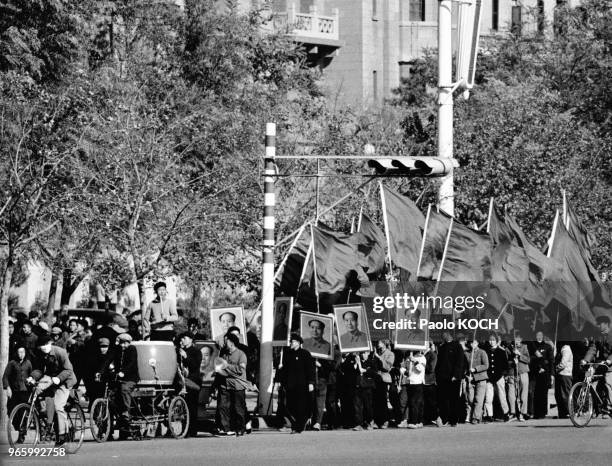 Foule défilant dans la rue avec des portraits de Mao Zedong pour célébrer le lancemant d'un missile nucléaire, à Pékin, en Chine, le 28 octobre 1966.