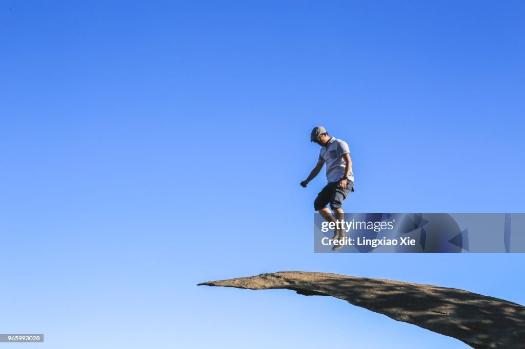 Man jumping on Potato Chip Rock, Mt. Woodson Summit, California