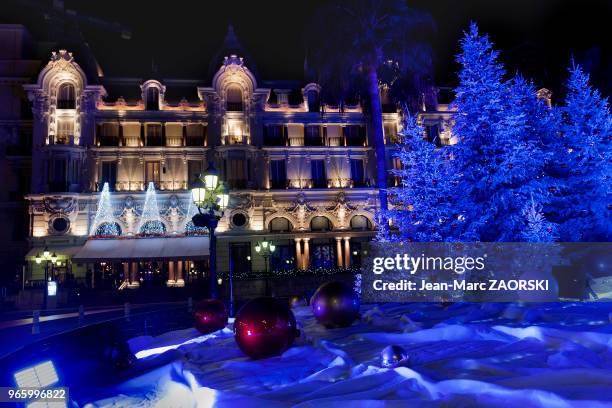 Ambiance de Noël avec un jeu de lumières colorées sur sapins enneigés et en arrière plan, la façade de « L'Hôtel de Paris » et du restaurant « Le...