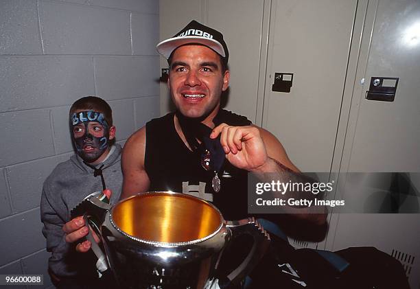 Greg Williams of the Blues celebrates with the premiership trophy and the Coleman medal after the 1995 AFL Grand Final match between Carlton and...