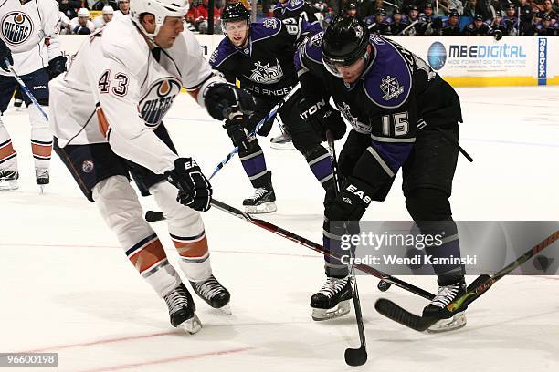 Jason Strudwick of the Edmonton Oilers reaches for the puck against Brad Richardson of the Los Angeles Kings on February 11, 2010 at Staples Center...