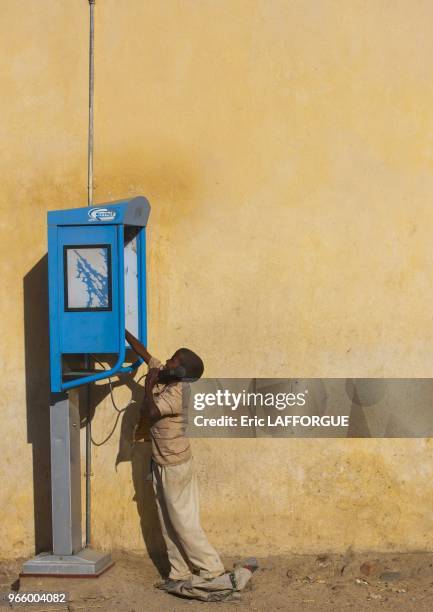 Enfant utilisant un telephone public le 25 fevrier 2013 a Keren, Erythree.