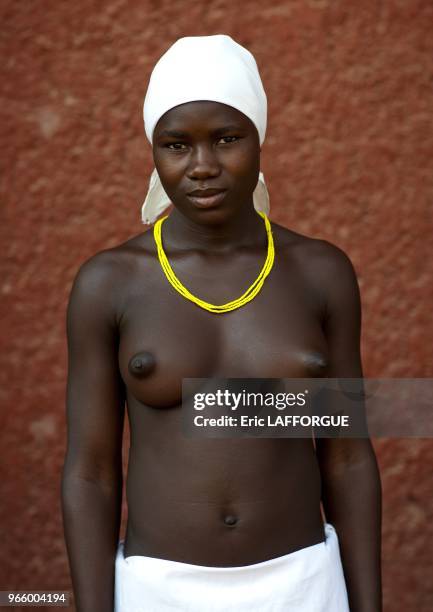 Woman who is a refugee from Angolan Civil War. They surviving by begging and posing topless for tourists in front of supermarkets.