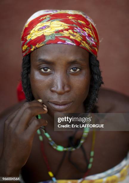 Woman who is a refugee from Angolan Civil War. They surviving by begging and posing topless for tourists in front of supermarkets.