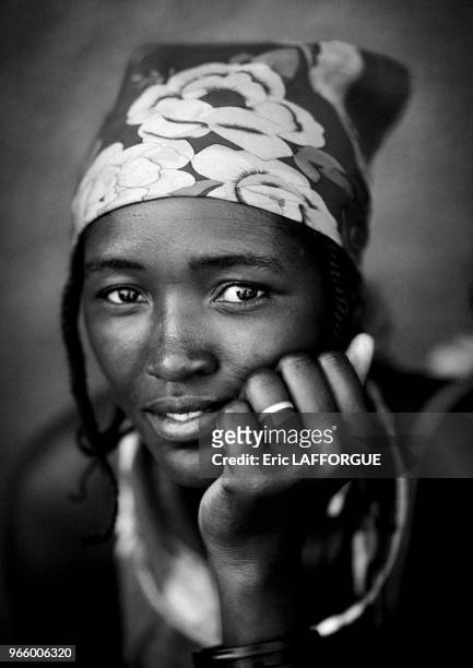 Woman who is a refugee from Angolan Civil War. They surviving by begging and posing topless for tourists in front of supermarkets.