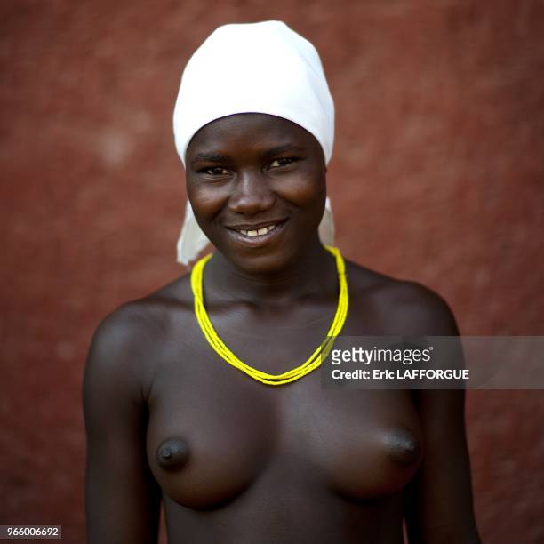 Woman who is a refugee from Angolan Civil War. They surviving by begging and posing topless for tourists in front of supermarkets.